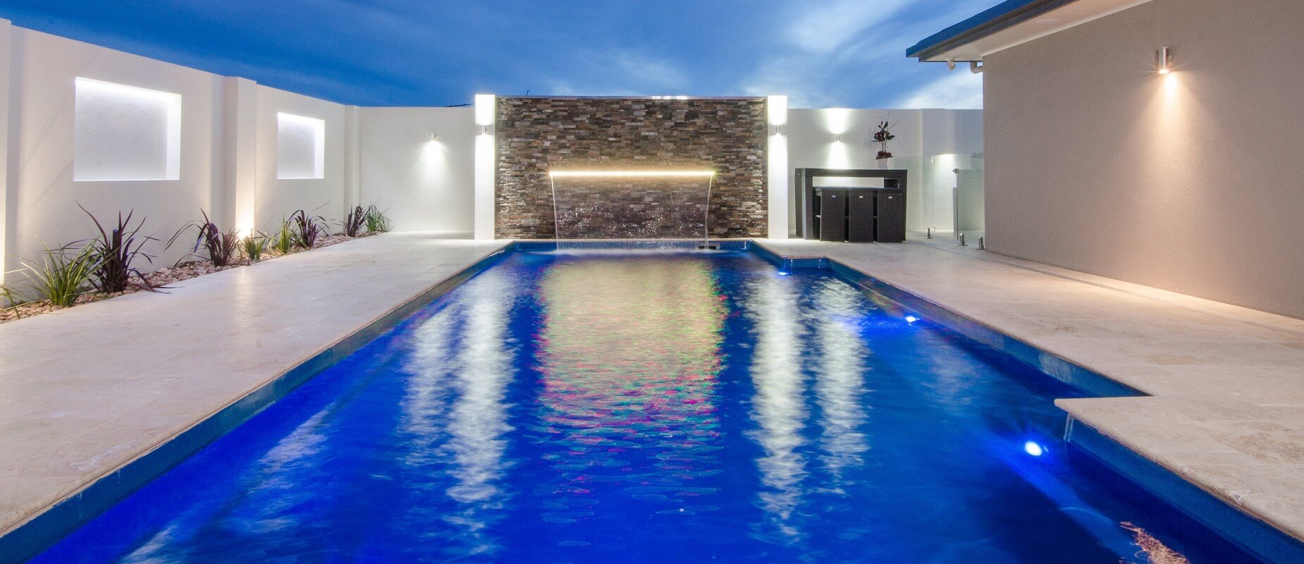 003-Compass-Pools-Australia_Vogue-family-pool-with-pool-lights-and-waterwall-water-feature